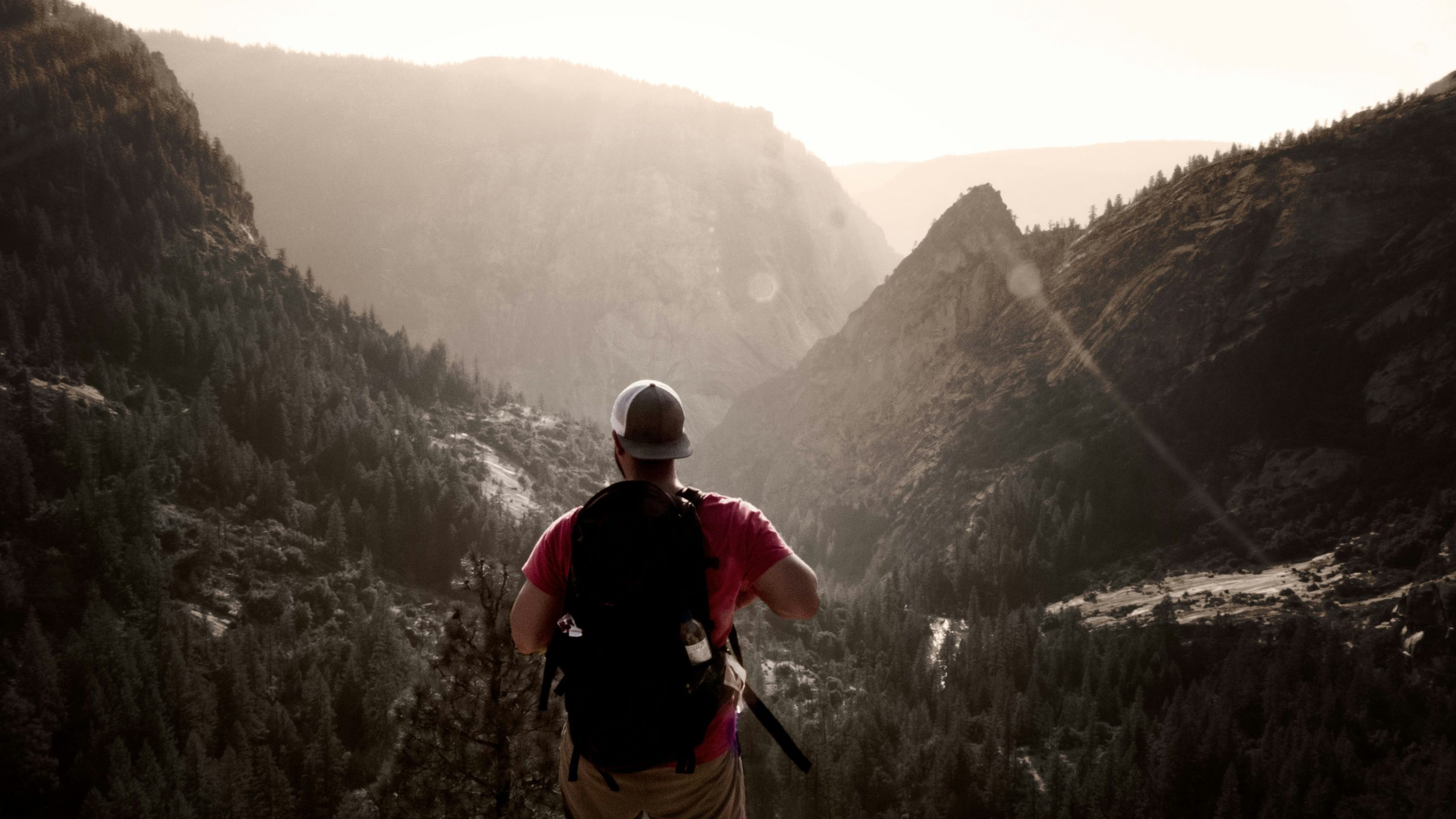 Hiker looking frustrated as his camera shows low battery warning amidst scenic backdrop