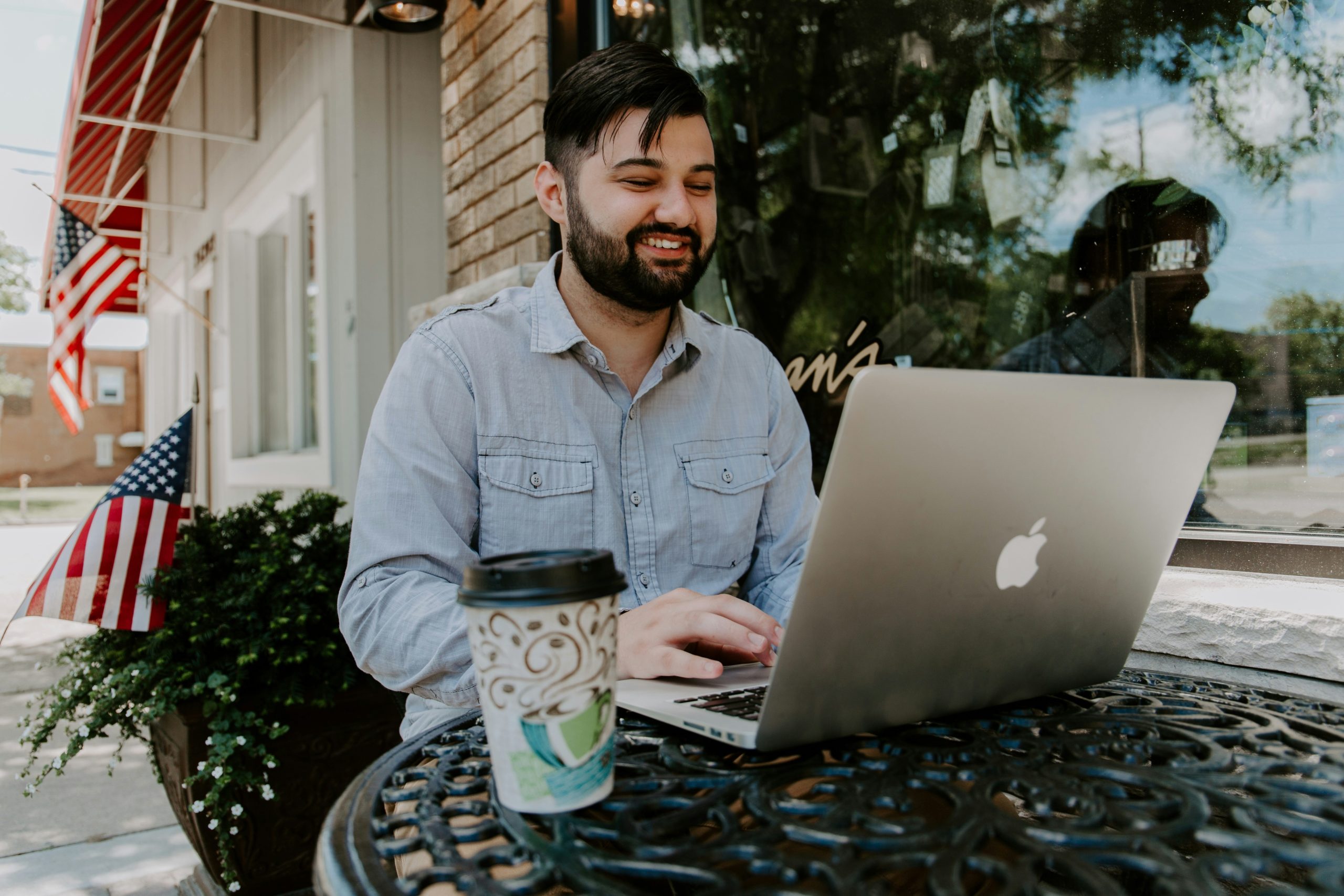 Man struggling to edit trail footage on laptop outdoors