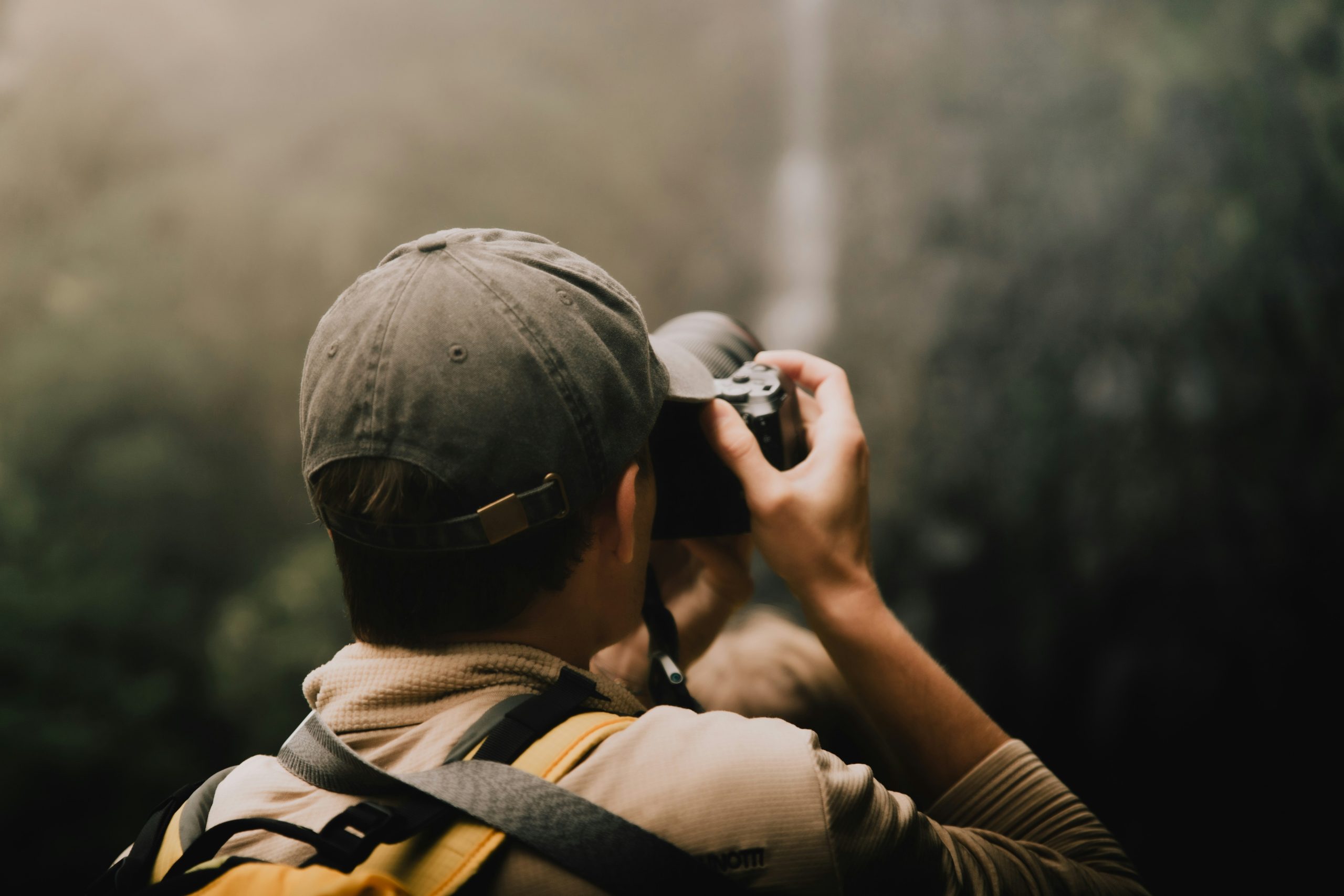 Smiling hiker holding their trail camera after successful recording session