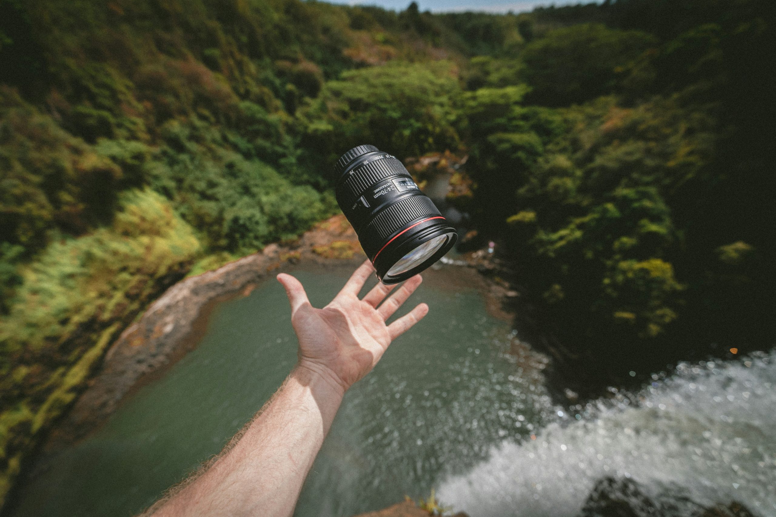 A photographer set up near a forest with tripod and long lens